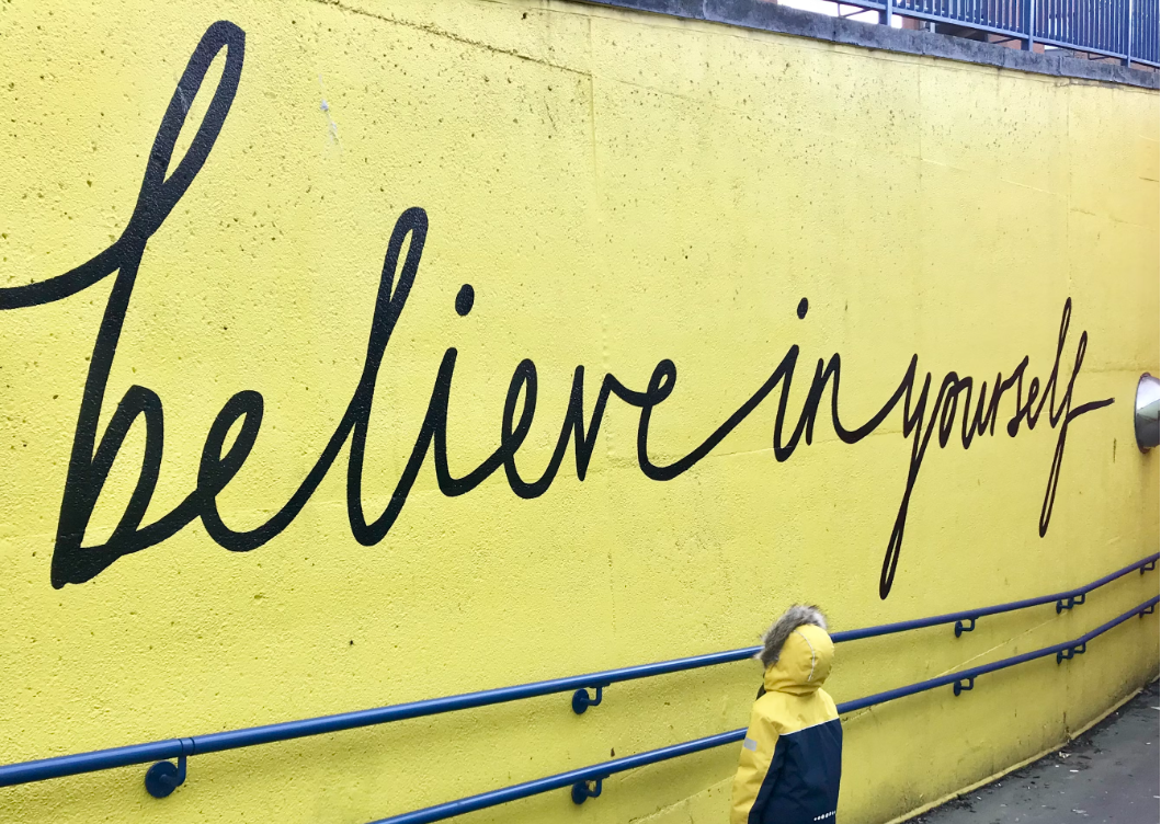 Graffiti on the wall saying “believe in yourself”